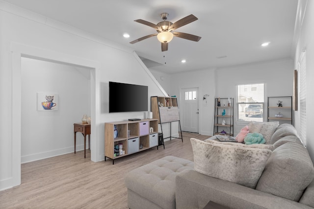 living room with ceiling fan, crown molding, and light hardwood / wood-style flooring