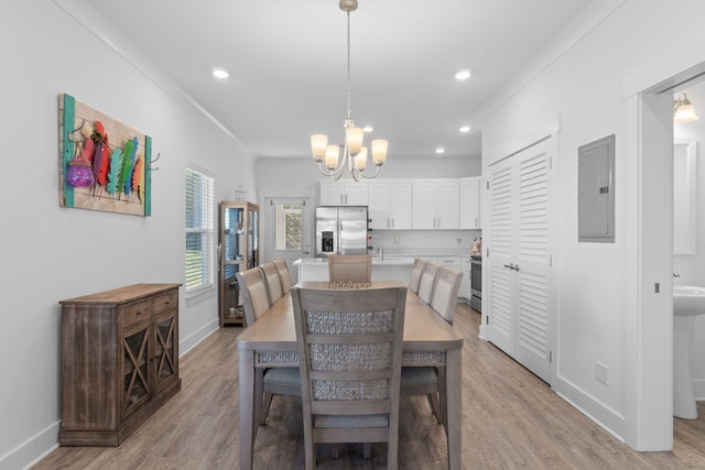 dining area featuring light wood-type flooring, electric panel, ornamental molding, and a notable chandelier