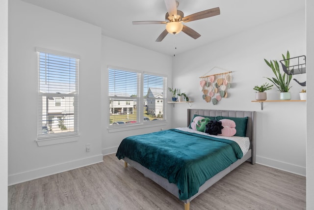 bedroom with light hardwood / wood-style flooring, multiple windows, and ceiling fan