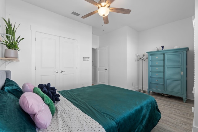 bedroom with a closet, hardwood / wood-style flooring, and ceiling fan