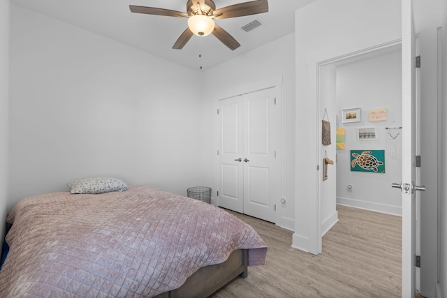 bedroom with ceiling fan, light wood-type flooring, and a closet