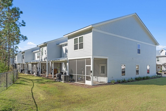 rear view of property featuring a sunroom and a yard