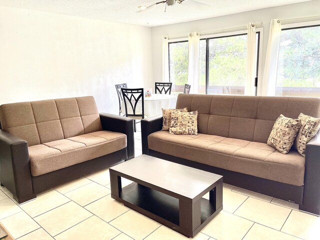 living room featuring a wealth of natural light, a textured ceiling, and light tile patterned flooring