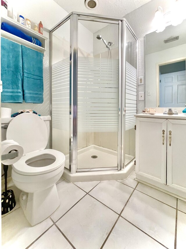 bathroom with toilet, tile patterned flooring, vanity, and a shower stall