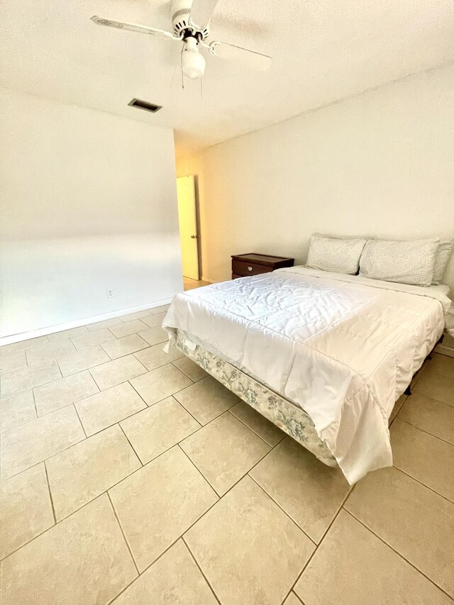 unfurnished bedroom with tile patterned flooring, visible vents, ceiling fan, and baseboards