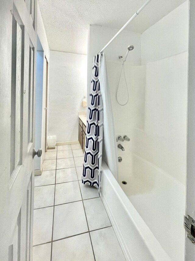 full bathroom featuring vanity, shower / tub combo with curtain, a textured ceiling, and tile patterned floors