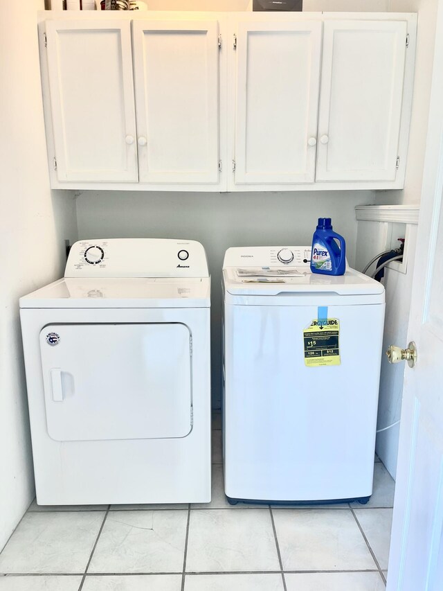 washroom featuring separate washer and dryer and cabinet space