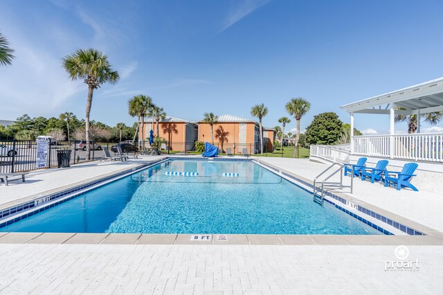 community pool featuring fence and a patio