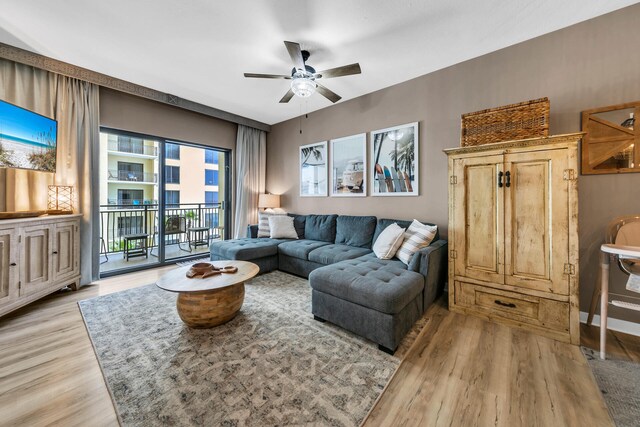 living room featuring light hardwood / wood-style flooring, ceiling fan, and a healthy amount of sunlight