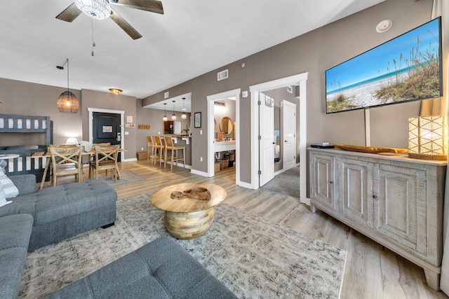 living room with light hardwood / wood-style flooring and ceiling fan