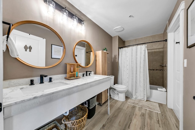 full bathroom with hardwood / wood-style floors, vanity, toilet, and shower / bath combo with shower curtain