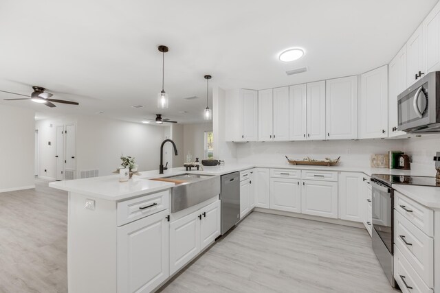 kitchen featuring appliances with stainless steel finishes, kitchen peninsula, ceiling fan, and white cabinets