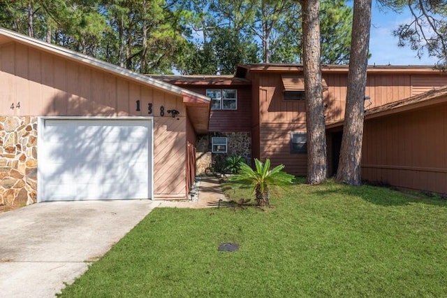 view of front of house with stone siding, driveway, and a front lawn