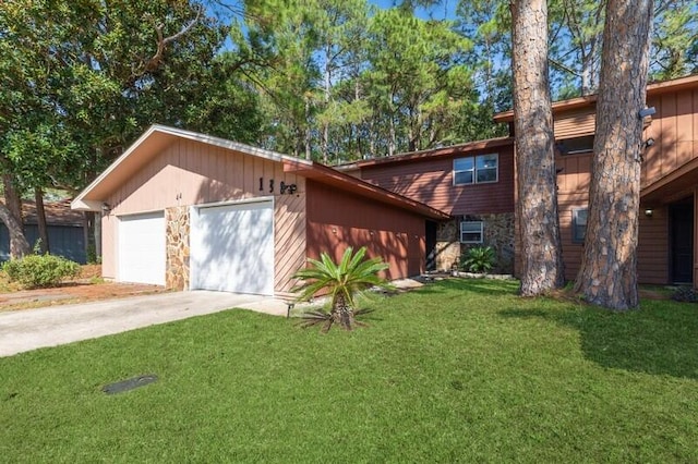 view of front of home featuring stone siding, driveway, a front lawn, and an attached garage