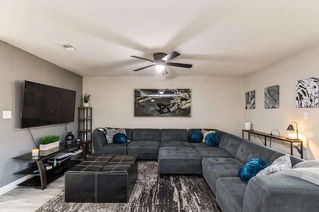 living room featuring visible vents, wood finished floors, a ceiling fan, and baseboards