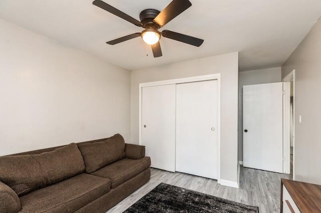 living room featuring light wood-style floors and a ceiling fan