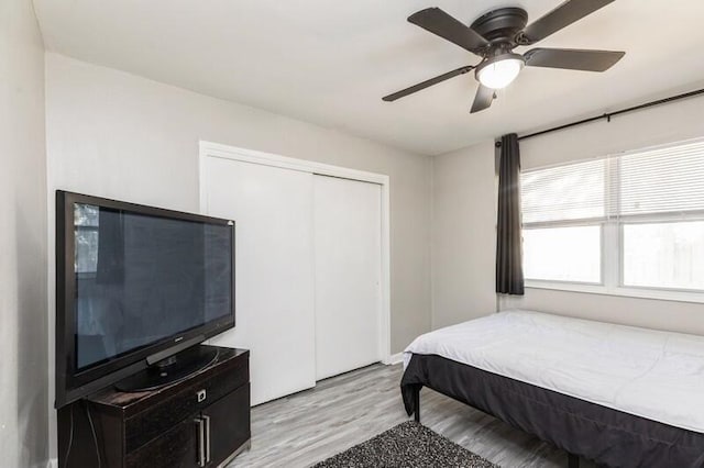 bedroom with a closet, light wood-type flooring, and a ceiling fan