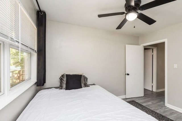 bedroom with dark wood-style floors, baseboards, and a ceiling fan