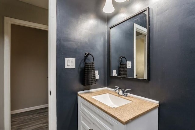 bathroom featuring baseboards, wood finished floors, and vanity