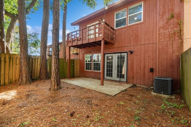 back of house featuring a patio area, a fenced backyard, central AC, and french doors