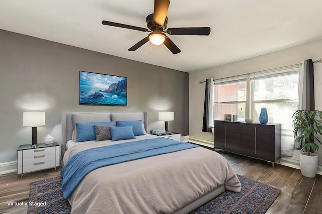 bedroom featuring ceiling fan, dark wood-style flooring, and baseboards