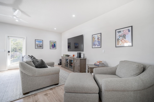 living room with light hardwood / wood-style flooring and ceiling fan