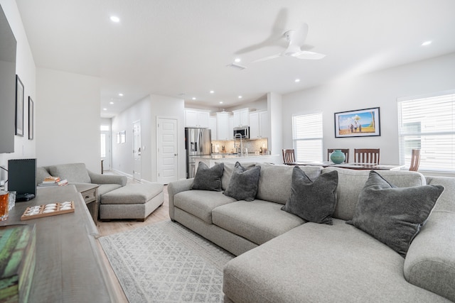 living room featuring ceiling fan and light hardwood / wood-style flooring