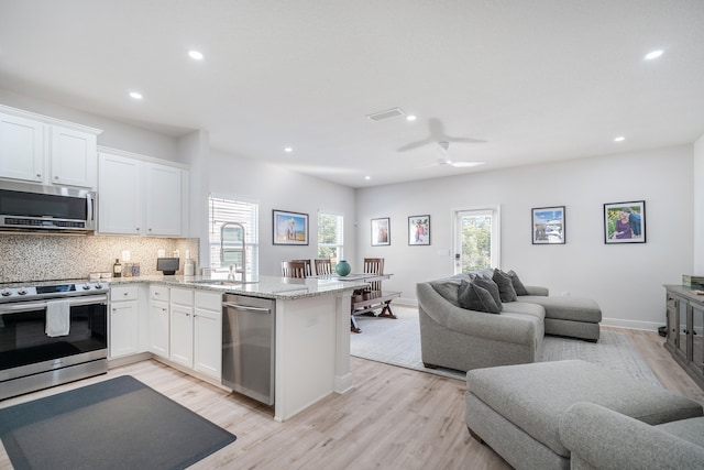 kitchen featuring ceiling fan, white cabinets, sink, light hardwood / wood-style flooring, and appliances with stainless steel finishes