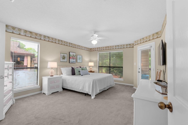 bedroom featuring multiple windows, access to outside, light carpet, and ceiling fan