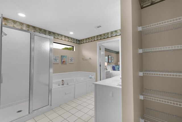 bathroom featuring plus walk in shower, vanity, and tile patterned floors