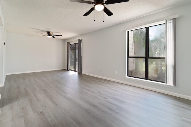 spare room with ceiling fan, light hardwood / wood-style floors, and a textured ceiling