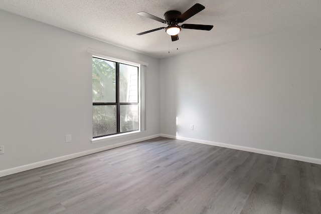 empty room featuring ceiling fan, a textured ceiling, and light wood-type flooring