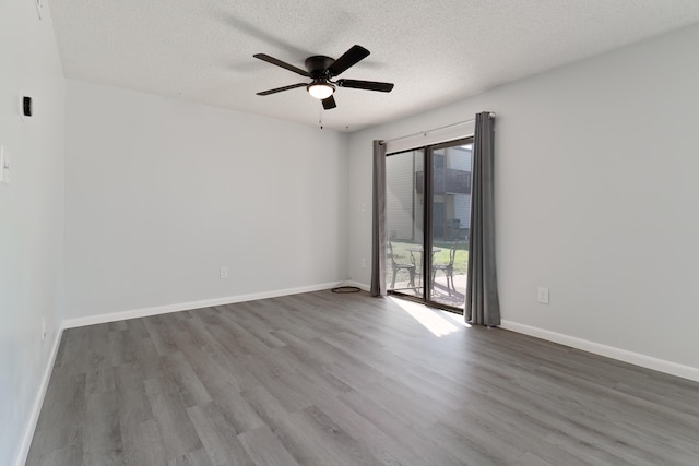 spare room featuring ceiling fan, wood-type flooring, and a textured ceiling