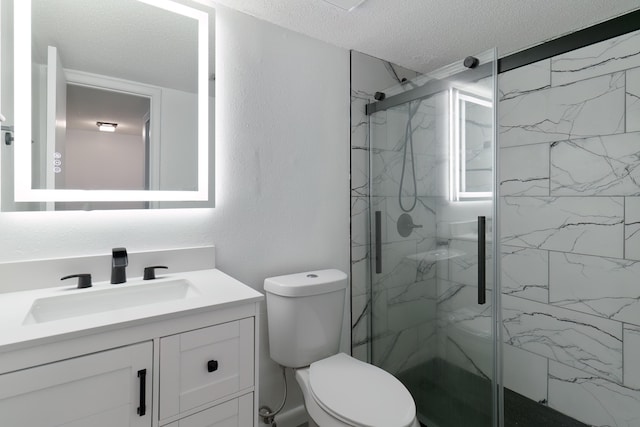 bathroom featuring vanity, toilet, an enclosed shower, and a textured ceiling