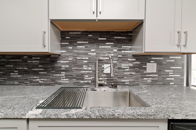 kitchen with light stone countertops and white cabinets