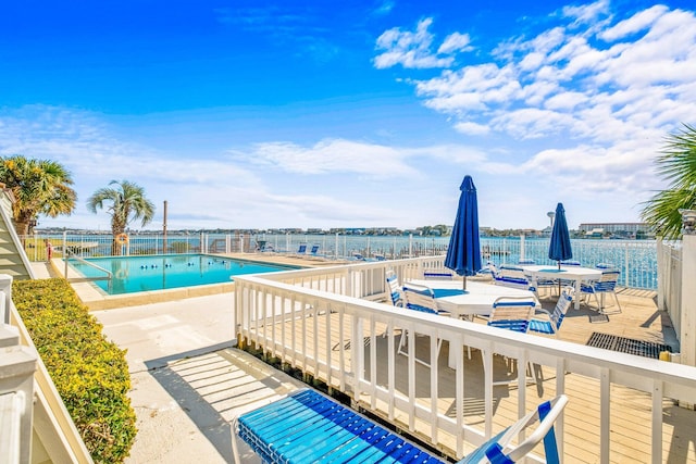 view of pool with a water view and a patio area