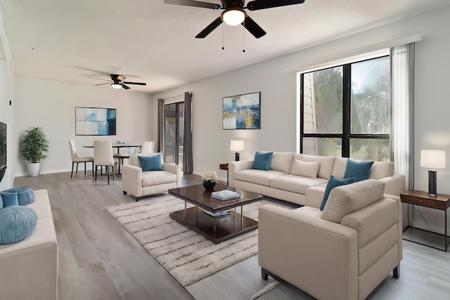 living room with light hardwood / wood-style flooring and ceiling fan