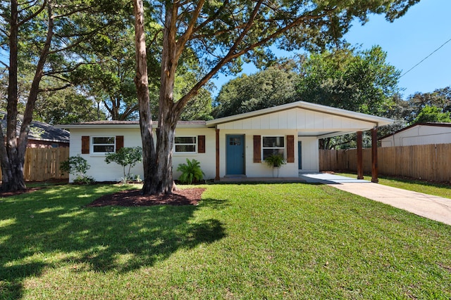 ranch-style home featuring a front yard, a carport, and covered porch