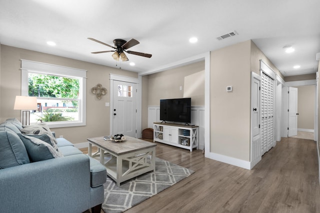 living room with dark hardwood / wood-style floors and ceiling fan