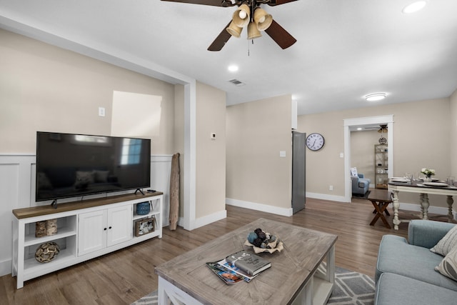 living room with dark hardwood / wood-style floors and ceiling fan