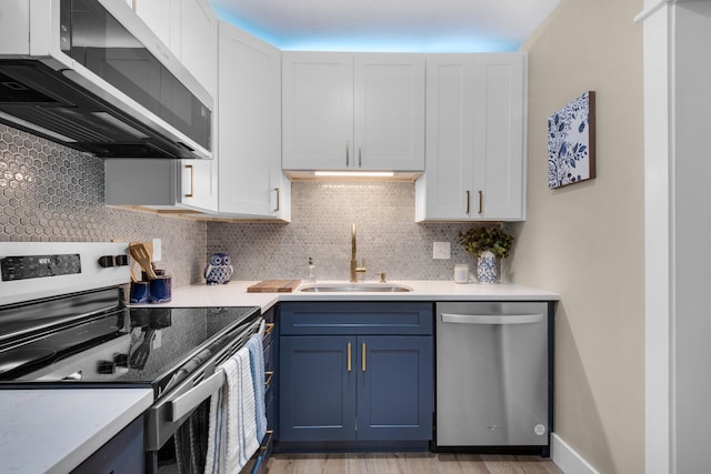 kitchen featuring appliances with stainless steel finishes, backsplash, blue cabinets, sink, and white cabinets