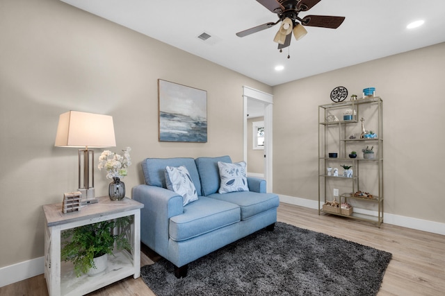 living room featuring light hardwood / wood-style floors and ceiling fan