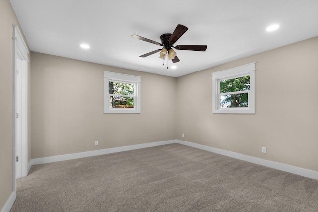 unfurnished room featuring ceiling fan, plenty of natural light, and light colored carpet