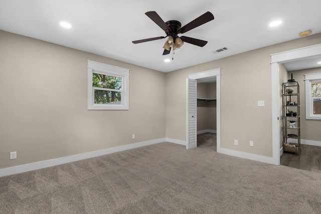 unfurnished bedroom with carpet, ceiling fan, and a walk in closet