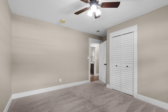 unfurnished bedroom featuring carpet, ceiling fan, and a closet