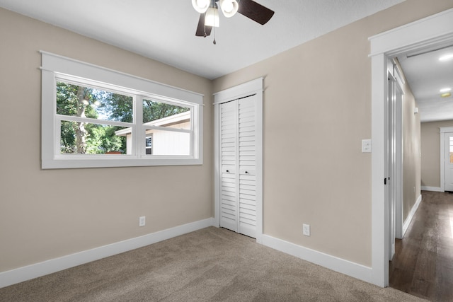 unfurnished bedroom featuring carpet flooring, ceiling fan, and a closet