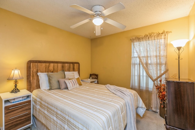 carpeted bedroom featuring ceiling fan and a textured ceiling