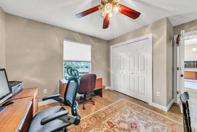 office space with ceiling fan, a textured ceiling, and light hardwood / wood-style floors