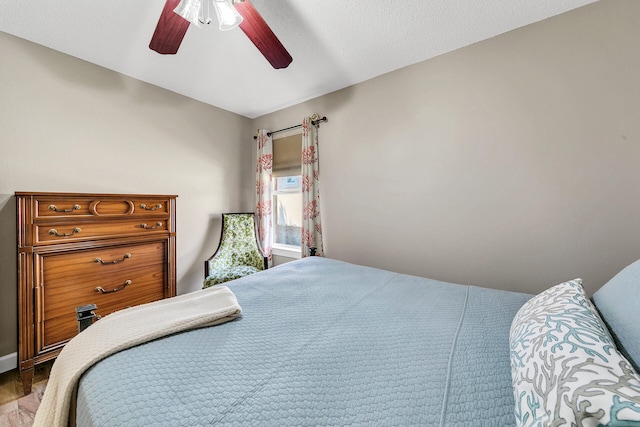 bedroom with ceiling fan, light hardwood / wood-style flooring, and lofted ceiling