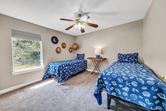 carpeted bedroom featuring ceiling fan and a textured ceiling